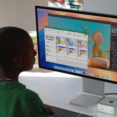 En kvinne jobber i et Excel-regneark på en Mac, sittende ved et arbeidsbord. Excel-regnearket er sporer salget for fjerde kvartal. Bak Excel-vinduet er det et Pixelmator Pro-vindu.