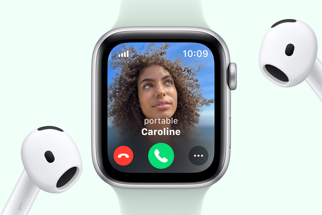 Apple Watch SE affichant un appel entrant, à côté d’une paire d’AirPods