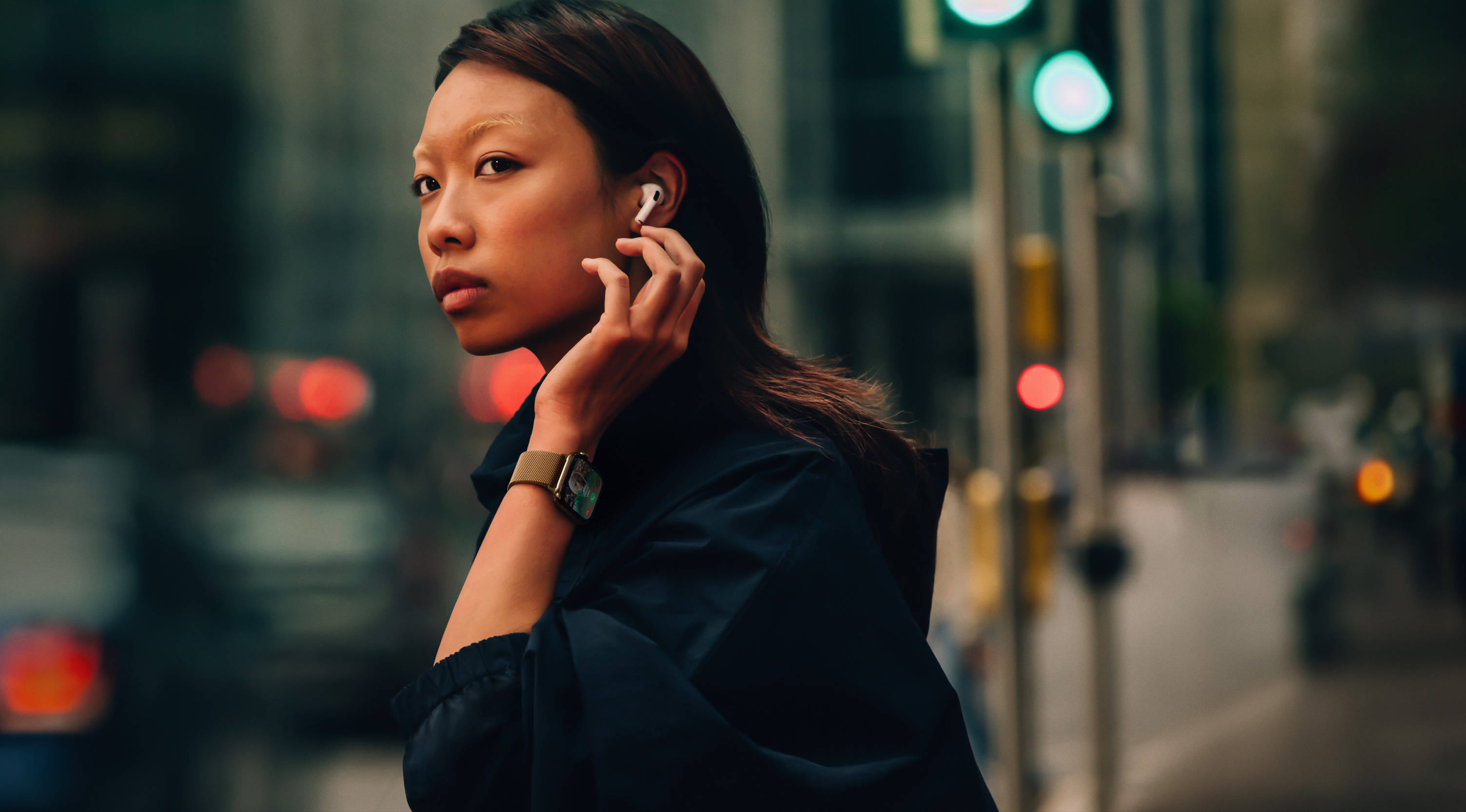 Apple Watch Series 10とAirPodsを装着して街にいる女性