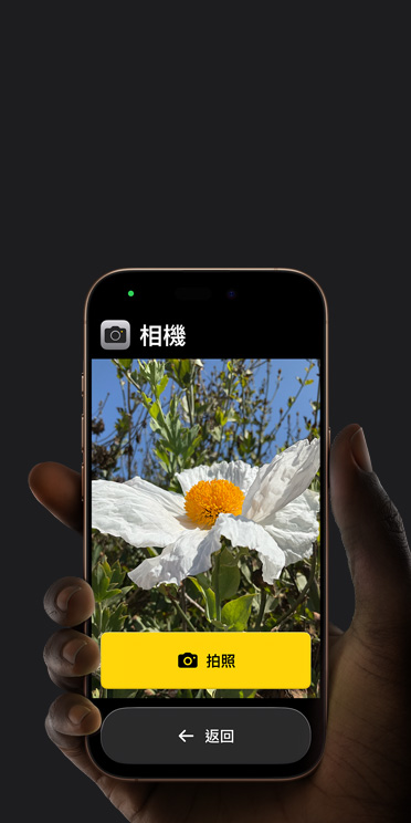 iPhone 16 Pro 螢幕展示簡化的相機 app 介面，取景框中有一朵白色的花和「拍照」按鈕，底下還顯示「返回」按鈕