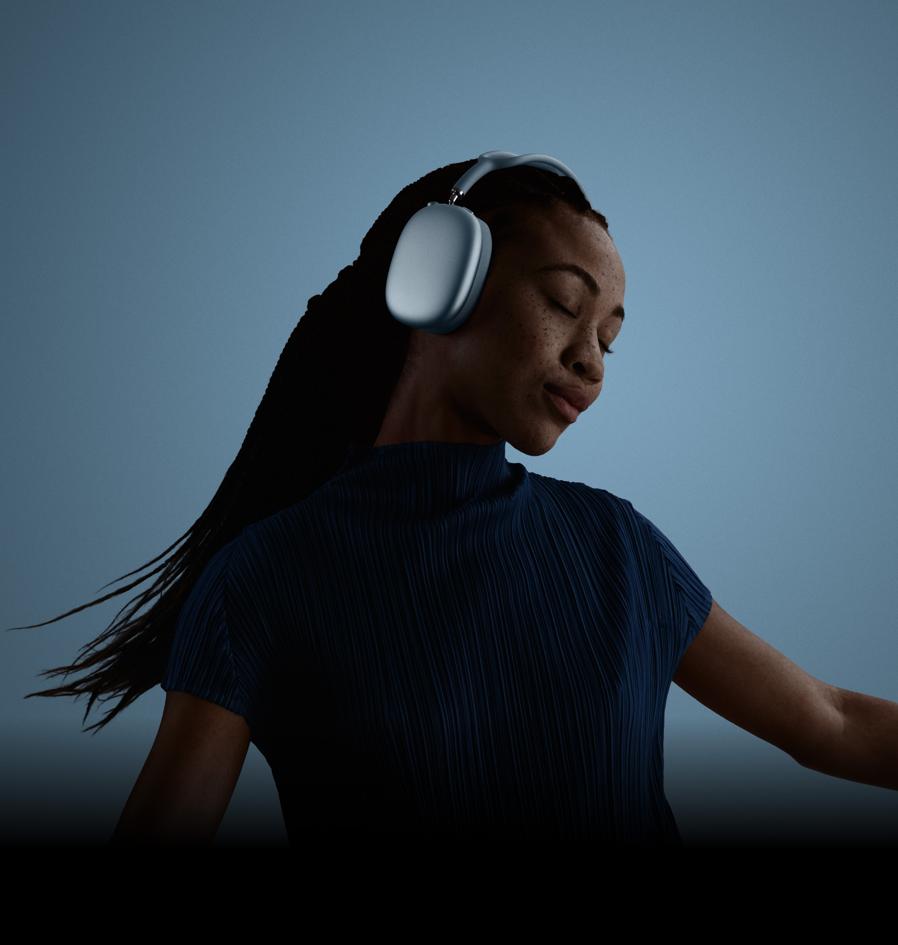 سيدة ترتدي سماعات AirPods Max، عيناها مغلقتان ورأسها مائل إلى اليسار.