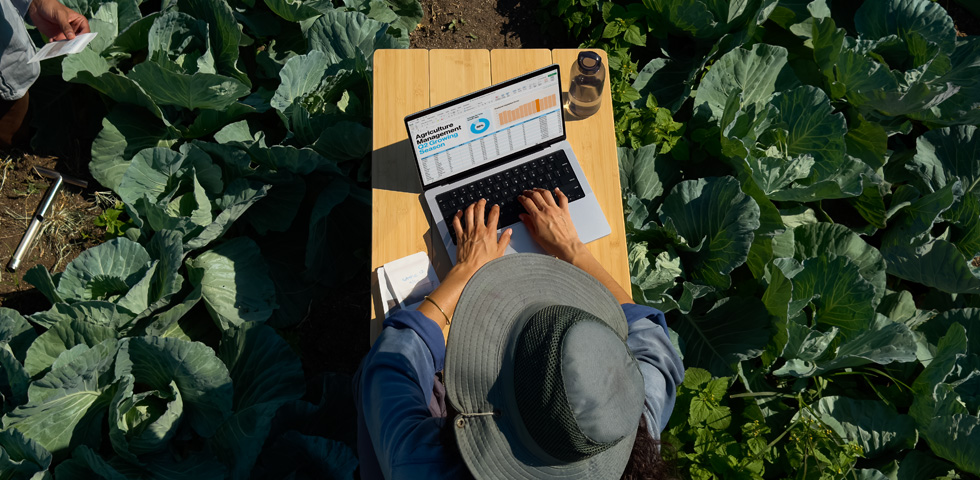 Iemand gebruikt een MacBook Pro met display met nanotextuur in de buitenlucht, ter illustratie van het feit dat je met dit type display minder last hebt van schitteringen